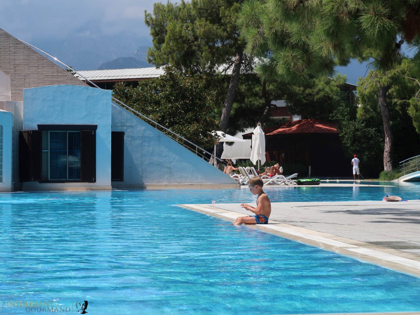 Rixos Sungate Kemer Antalya with Jet 2 Holidays - little boy sat on the side of a quiet swimming pool, contemplating. www.intolerantgourmand.com